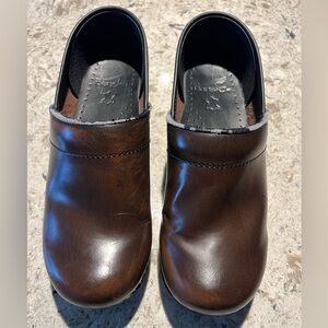 Dansko Dark Brown Leather Slip-On Clogs. The top line is peeling.